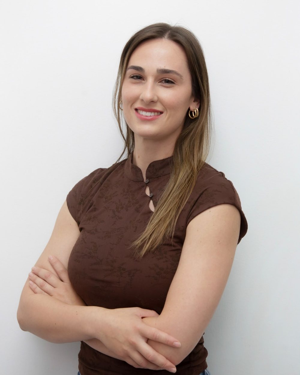 Myriam Molina con los brazos cruzados y sonriendo, delante de una pared blanca